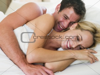 Couple lying in bed laughing