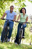 Couple on bikes outdoors smiling