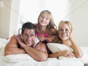 Family lying in bed smiling