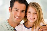 Man and young girl in living room smiling