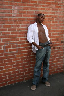 Handsome Male Model With Shirt Open Leaning Against Brick Wall