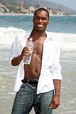Happy African American Man Drinking  Water on the Beach