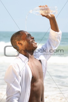 Happy African American Man Pouring Water Over His Head on the Be