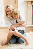 Woman in front hallway hugging young boy and smiling