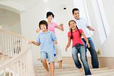 Family running down staircase smiling