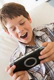 Young boy with handheld game indoors