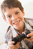 Young boy holding video game controller smiling