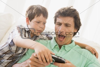 Young boy taking handheld game from unhappy man