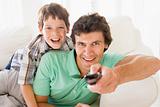 Man and young boy with remote control smiling