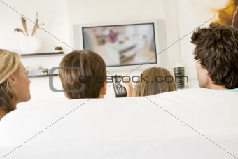 Family in living room with remote control and flat screen televi