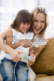Woman and young girl in living room with video game controllers 