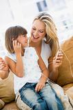 Woman and young girl in living room with MP3 player smiling
