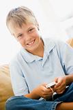Young boy in living room with MP3 player smiling