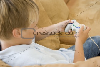 Young boy in living room with video game controller