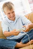 Young boy in living room with video game controller smiling
