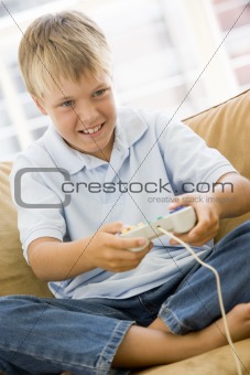 Young boy in living room with video game controller smiling