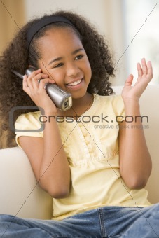 Young girl in living room using telephone and smiling