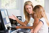 Woman and young girl in home office with computer looking unhapp