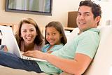 Family in living room with laptop smiling