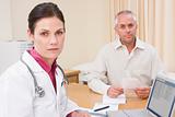 Doctor with laptop and man in doctor's office frowning