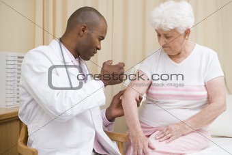 Doctor giving needle to woman in exam room