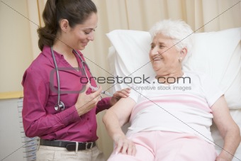 Doctor giving needle to woman in exam room smiling