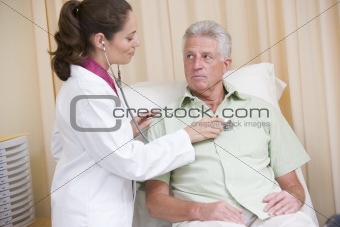 Doctor giving checkup with stethoscope to man in exam room
