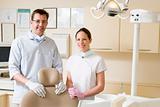 Dentist and assistant in exam room smiling