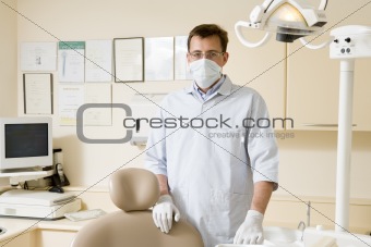 Dentist in exam room with mask on