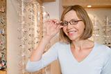 Woman trying on eyeglasses at optometrists smiling