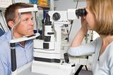 Optometrist in exam room with man in chair