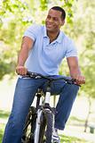Man outdoors on bike smiling