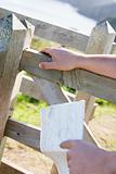 Man's hands on fence holding map