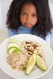 Young girl in kitchen eating rice fruit and nuts