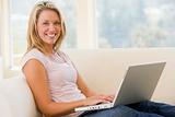 Woman in living room using laptop smiling