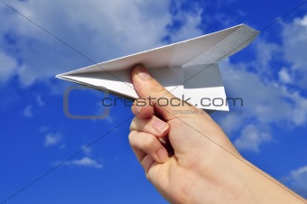 Hand holding paper airplane