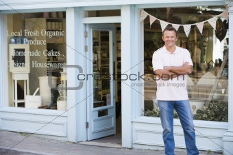 Man standing in front of organic food store smiling