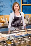 Woman standing at counter in restaurant smiling