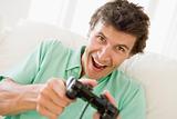 Man in living room playing videogames smiling