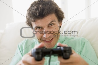 Man in living room playing videogames smiling