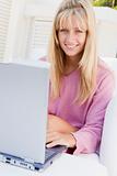 Woman on patio using laptop smiling