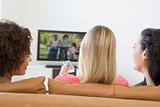 Three women in living room watching television