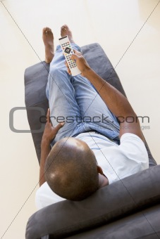 Man sitting in chair using remote control