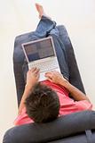 Man sitting in chair using laptop