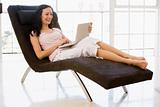 Woman sitting in chair using laptop smiling