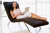 Woman sitting in chair using laptop smiling