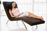 Woman sitting in chair with remote control smiling