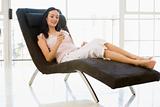 Woman sitting in chair listening to MP3 player smiling