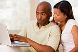Couple in living room using laptop