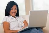 Woman in living room using laptop smiling